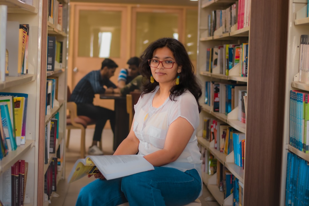 Estudiante con un libro en un entorno académico para explorar recursos del sitio